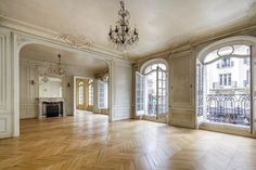 an empty room with wooden floors and chandelier