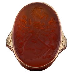 Victorian Signature Ring A Stunning Victorian period armorial ring, skillful hand crafted of solid 14 Kt gold Unique designed mount with flowers and leaf exalting the beauty of this ring Intricate coat of arms skillfully engraved on Carnelian stone rich and crisp details beautifully expressed in this past artwork Crown is 35 x 18 mm. h x w with 7.3 grams gross weight Fine condition keeping with age, sign of a previous re-sizing Sought after, beautiful example Unless otherwise stated boxes are for presentation only Further Details Below Metal: 14 Kt yellow gold Hallmarks: assay Gems: 1 oval carved carnelian of 23 x 17 mm. UK size: N 3/4 US size: 7 Measures: head is 25 x 18 mm. (h. x w.) Weight: 7.3 grams Gold Hallmarks, Signature Ring, Signature Rings, Victorian Period, Carnelian Stone, Coat Of Arms, Signet Ring, Hand Crafted, Jewelry Rings