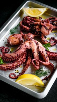 an octopus platter with lemon wedges and garnishes