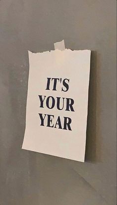 a piece of paper with the words it's your year written on it hanging on a wall