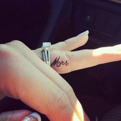 a person's hand with a ring on it and the word mom written in black ink