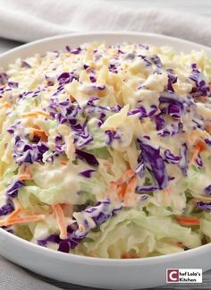 a white bowl filled with coleslaw and carrots on top of a table