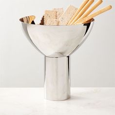 a white marble bowl filled with crackers and cookies on top of a countertop