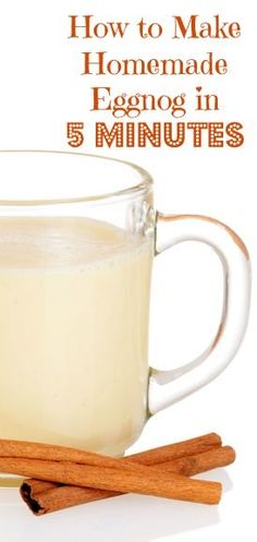 a glass mug filled with eggnog next to cinnamon sticks