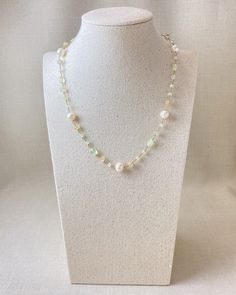 Indulge in the luxurious beauty of this exquisite gemstone and pearl beaded necklace. With its soft, airy sophistication and stunning combination of white freshwater pearls, pale green prehnite, and golden rutilated quartz, this piece is truly a work of art. I ensure every gemstone bead and pearl is meticulously wire-wrapped in 14k gold fill so that it will bring joy and beauty to your life for many years to come. And with its adjustable 2-inch extender chain, you can find the perfect fit to accentuate your natural style. Materials: cultured freshwater pearls, prehnite, golden rutilated quartz, gold fill Necklace length: 18 inches plus 2-inch extender White Pearl Crystal Necklace With Gemstone, White Pearl Crystal Gemstone Necklace, White Pearl Crystal Necklaces With Gemstone, Green Pearl Drop Beaded Necklaces, Green Pearl Necklace With Natural Stones, White Briolette Pearl Necklace, Gold Jade Necklace With Faceted Beads, Elegant Faceted Jade Beaded Necklace, Green Faceted Beads Pearl Necklace For Gift