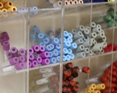 there are many different colored sprinkles in the bins on the wall