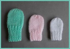 three knitted mittens sitting next to each other on top of a gray surface