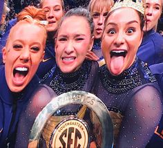 the cheerleaders pose for a photo with their trophy