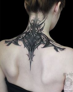 the back of a woman's neck with an intricate design on it