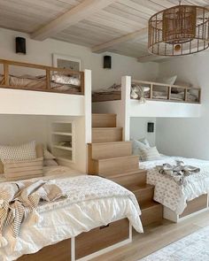 two beds in a room with wooden stairs