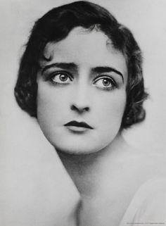 an old black and white photo of a woman's face with eyes wide open