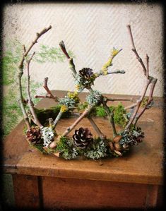 a wooden table topped with branches and pine cones