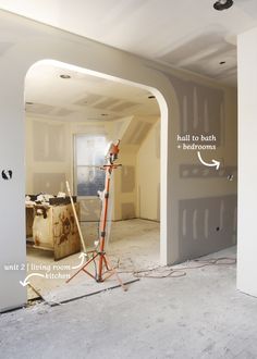 an unfinished room with the walls being painted and tools in the foreground are on the floor