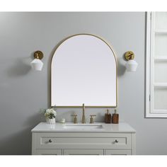 a bathroom vanity with an oval mirror and gold faucet on the wall above it