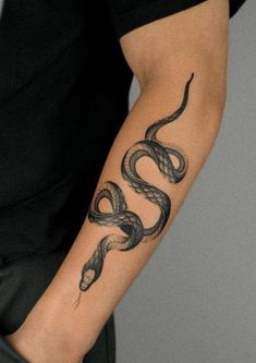 a man's arm with a tattoo on it that has a snake on it