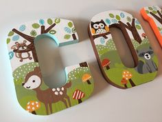 the wooden letters are decorated with animals and trees