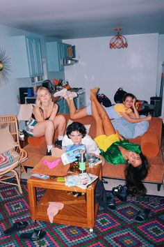 three women laying on the couch in a living room