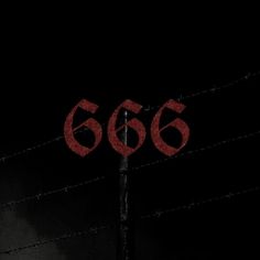 a red 666 sign on top of a metal pole with barbed wire in the background