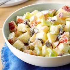 a white bowl filled with fruit salad on top of a blue napkin