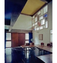 an empty room with several tables and chairs in it, all facing different directions to the ceiling