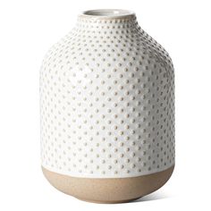 a white vase with brown dots on it