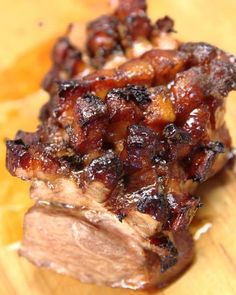 two pieces of meat sitting on top of a wooden cutting board