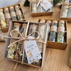 several small boxes filled with different types of spices and tags tied to them on top of a wooden table