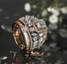 a diamond ring sitting on top of a table next to some white and pink flowers