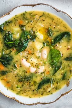 a white bowl filled with vegetable soup on top of a table