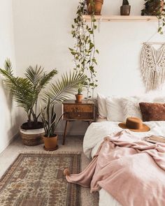 a bedroom with plants and rugs on the floor