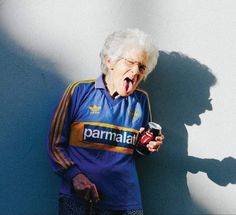 an old woman holding a can of beer and making a face with her mouth open