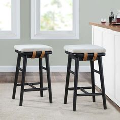 two stools in front of a counter with bottles on it