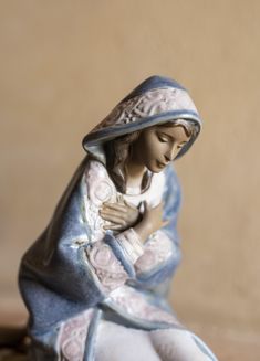 a statue of the virgin mary holding a baby jesus in her arms, sitting on a table