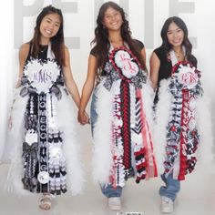 three young women are holding hands and posing for the camera with their dresses made out of feathers