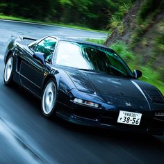 a black sports car driving down the road