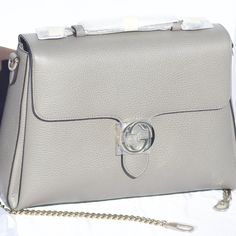 The Gucci Large Top Handle Interlocking Gg Crossbody In Gray Is Crafted From Dollar Calf, Pebbled Leather In Italy. This Bag Has A Large Construction With Walls Going Inward To A Trapezoid Shape. It Features An Interlocking Gg Clasp, Top Handle, Removable And Adjustable Leather Shoulder Strap, And 2 Interior Compartments. Gray Large Top Handle Interlocking Gg Crossbody Gold-Tone Hardware (Gentle Cold With Silver Hues) 100% Dollar Calfskin Leather Large Shoulder, Crossbody Bag Top Flap With Magne Designer Gucci Silver Bag, Silver Gucci Evening Bag, Designer Silver Gucci Bags, Gucci Diaper Bag, Dionysus Super Mini Bag, Gucci Dionysus Super Mini, Gucci Messenger Bags, Navy Purse, Soho Disco Bag