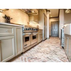 a kitchen with an oven, refrigerator and sink in it's center area is shown