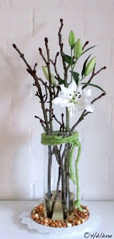 a vase filled with branches and flowers on top of a table