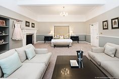 a living room filled with furniture and a fire place next to a white bed in a bedroom