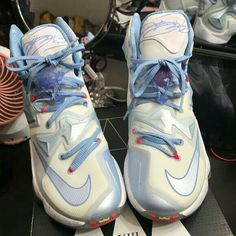 a pair of sneakers with blue and white laces are on top of a box