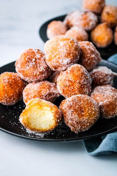 some sugared doughnuts on a black plate with the words hawaii's favorite mochi donuts