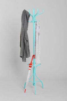 an ironing board and coat rack with two coats hanging on it's sides