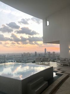 an outdoor hot tub overlooking the city at sunset