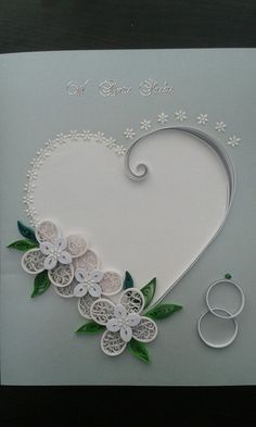 a heart shaped card with flowers on it and scissors next to it in the shape of a heart