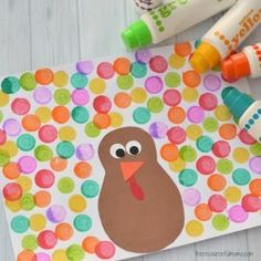 a turkey craft with crayons and markers on the side, next to it