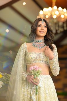 a woman in a wedding dress posing for the camera with her bridal outfit on