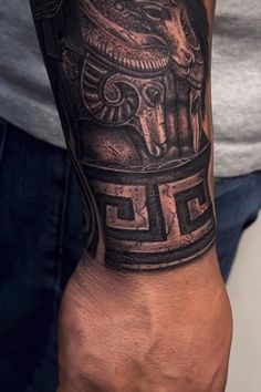 a man's arm with a black and grey tattoo design on it, including an elephant