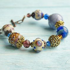 "This Lavender boho bracelet bracelet is a perfect gift for women. It's very tender and unique! This lampwork bracelet fits a 15.5-16.5cm (6.1\"-6.5\" inch) diameter wrist. If you need bigger or smaller size bracelet, please, write me the diameter of your wrist when making an order. Dimentions: 21cm. Materials: artist lampwork beads, metal and glass beads, metal fittings. Colors used: blue, lavender, lilac. Please, note, each lampwork bead is made by hand and may differ slightly. All the photos Bohemian Beaded Bracelets With Round Beads As Gifts, Adjustable Bohemian Crystal Bracelet With Large Beads, Adjustable Bohemian Czech Glass Beaded Bracelets, Bohemian Bracelets With Colorful Beads As Gift, Bohemian Bracelet With Faceted Beads, Bohemian Czech Glass Beads Bracelet, Bohemian Czech Glass Bracelets With Large Beads, Bohemian Bracelets With Spacer Beads As Gift, Bohemian Crystal Bracelet With Large Beads For Gift