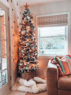 a living room with a christmas tree in the corner next to a couch and window