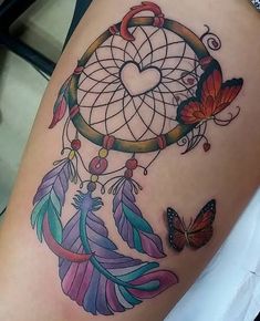 a woman's thigh with a dream catcher tattoo on it and butterflies flying around